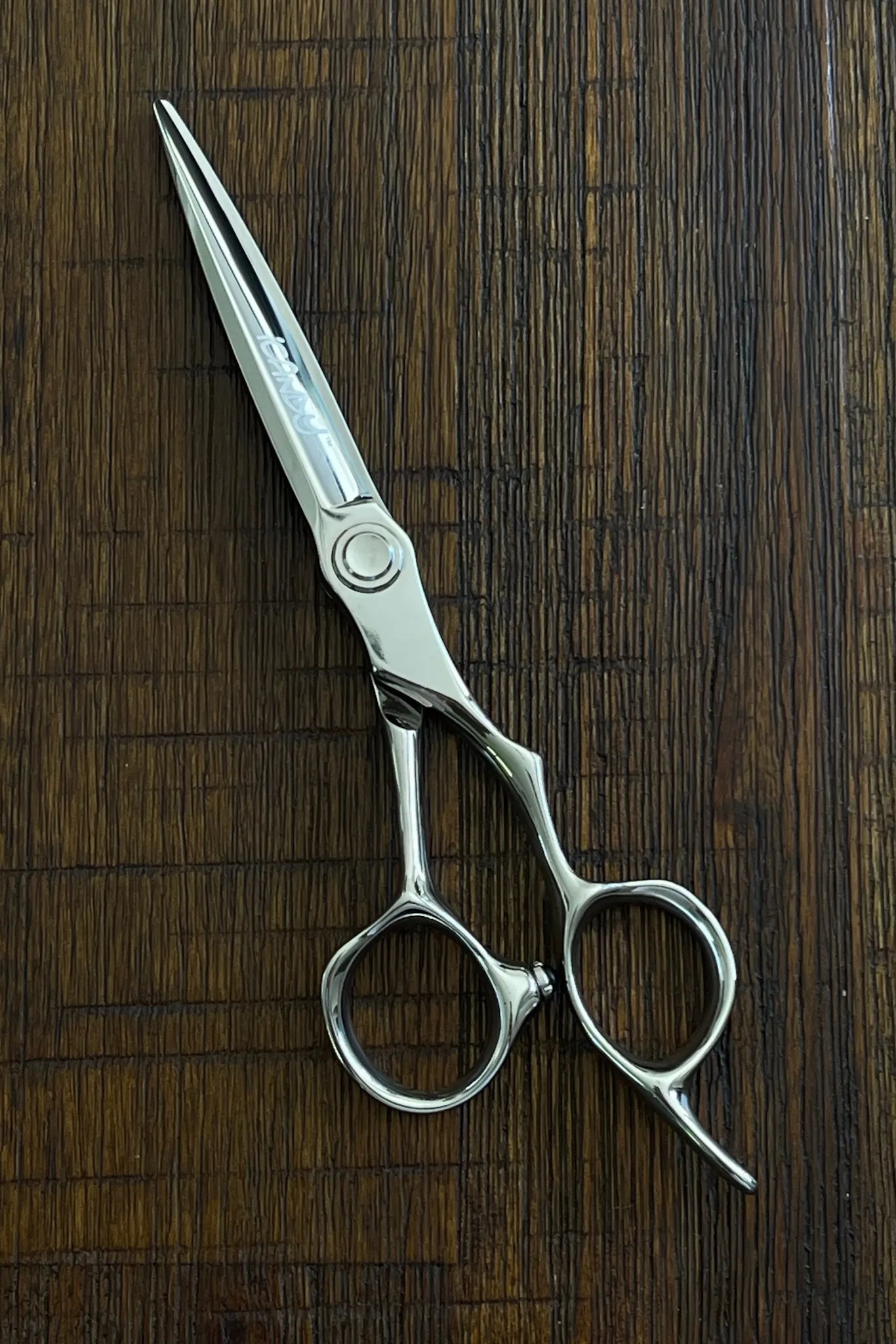 Professional hairstylist using iCandy EVOLVE Silver VG10 scissors in a salon, demonstrating smooth precision cutting, ergonomic comfort and balanced control for everyday professional hairdressing.