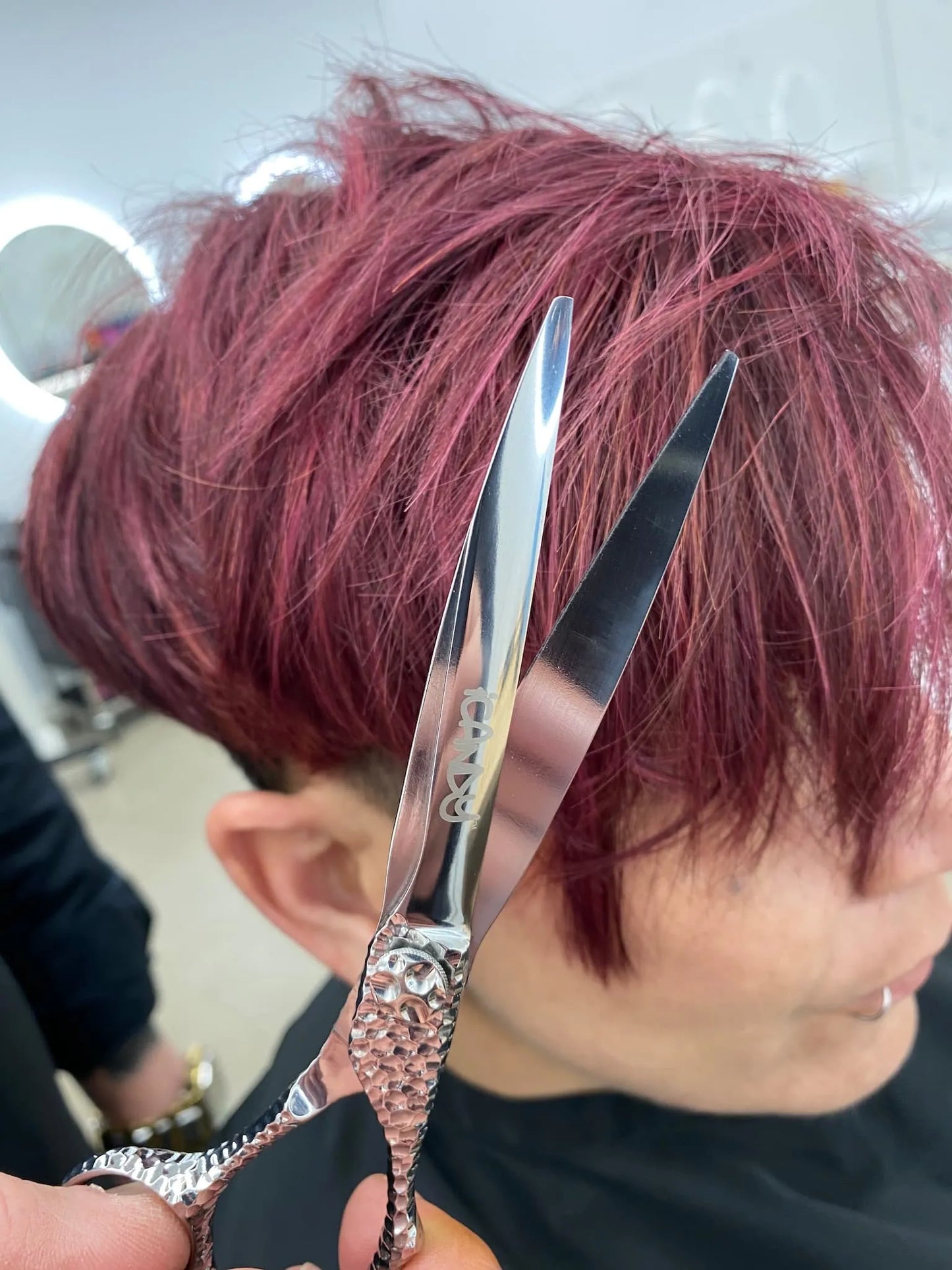Professional hairstylist creating precision layers with iCandy SWORD PRO Silver VG10 scissors, demonstrating smooth cutting performance, ergonomic comfort and creative confidence behind the salon chair.